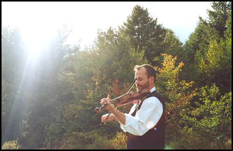 Photo of Brendan Taaffe playing the fiddle outdoors.